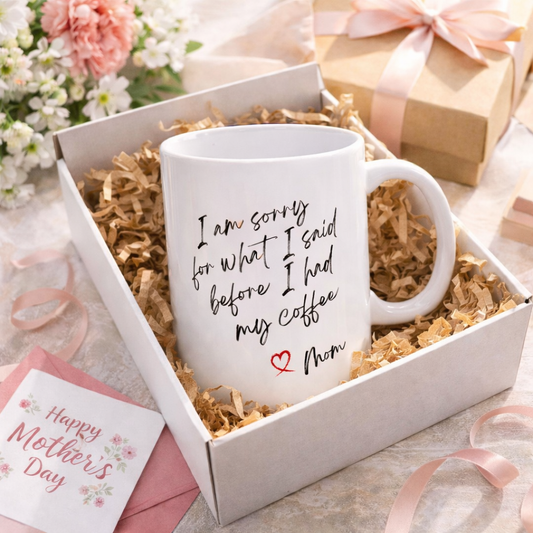 White mug with a message in a gift box with flowers and a card in the background